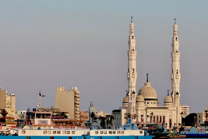 Eine Fähre und eine Moschee am Hafen von Port Said